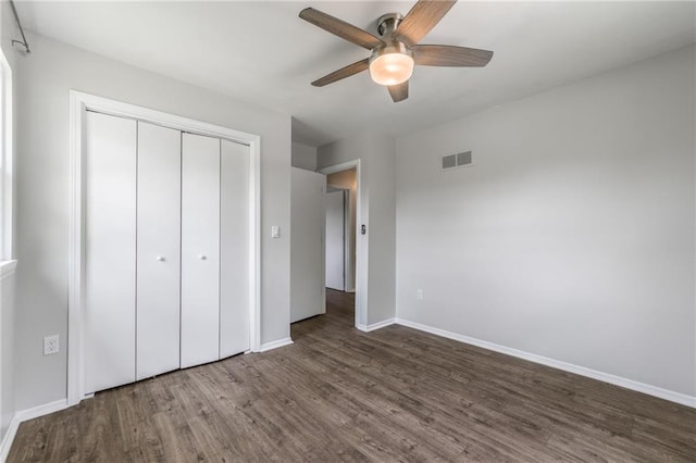 10908 Indiana Ave, Kansas City, MO 64137 - unfurnished bedroom featuring dark wood finished floors, a closet, baseboards, and a ceiling fan