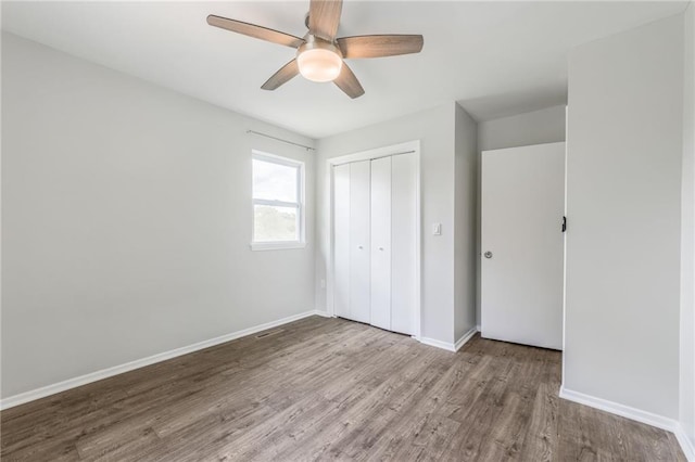 10908 Indiana Ave, Kansas City, MO 64137 - unfurnished bedroom with wood finished floors, a closet, baseboards, and ceiling fan