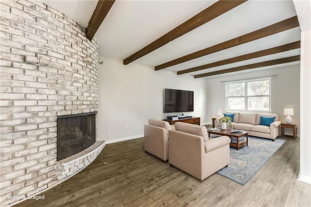 10908 Indiana Ave, Kansas City, MO 64137 - living room with beam ceiling, a brick fireplace, wood finished floors, and baseboards