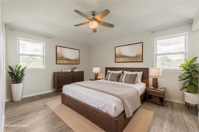 10908 Indiana Ave, Kansas City, MO 64137 - bedroom featuring light wood-type flooring, multiple windows, baseboards, and ceiling fan