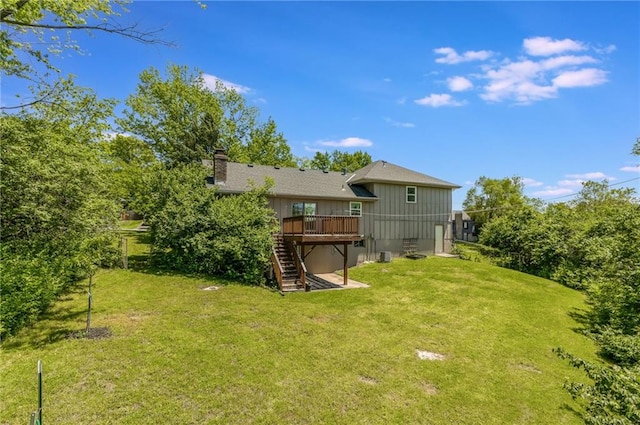 10908 Indiana Ave, Kansas City, MO 64137 - back of property with stairs, a deck, board and batten siding, a chimney, and a yard