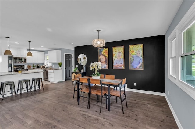 807 N Main St, Carrollton, MO 64633 - dining area featuring an accent wall, recessed lighting, baseboards, and wood finished floors
