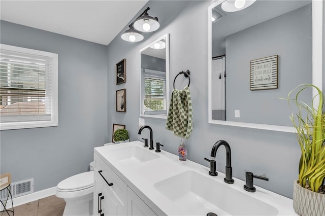 807 N Main St, Carrollton, MO 64633 - full bath with toilet, double vanity, tile patterned floors, and baseboards