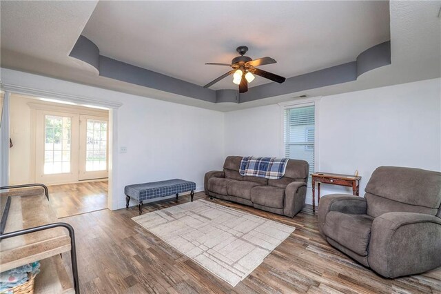 1101 S Independence St, Harrisonville, MO 64701 - living area featuring a raised ceiling, a ceiling fan, wood finished floors, and baseboards