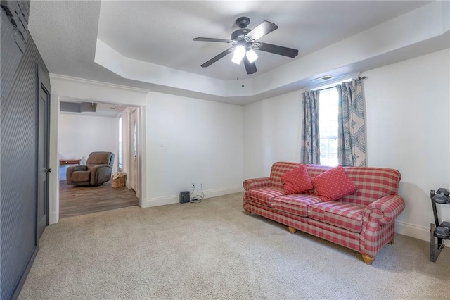 1101 S Independence St, Harrisonville, MO 64701 - living area featuring carpet floors, ceiling fan, a raised ceiling, and baseboards