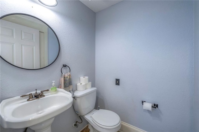 1101 S Independence St, Harrisonville, MO 64701 - half bathroom featuring a sink, toilet, and baseboards