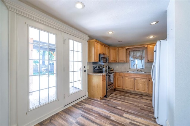 1101 S Independence St, Harrisonville, MO 64701 - kitchen with appliances with stainless steel finishes, a sink, light countertops, light wood-style flooring, and healthy amount of natural light