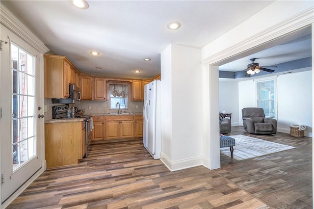 1101 S Independence St, Harrisonville, MO 64701 - kitchen with stainless steel appliances, a sink, light countertops, wood finished floors, and baseboards