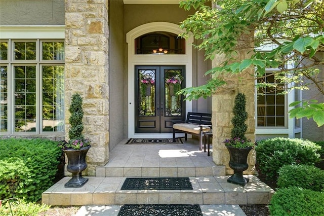 14301 Briar St, Leawood, KS 66224 - view of exterior entry featuring stone siding, stucco siding, and french doors