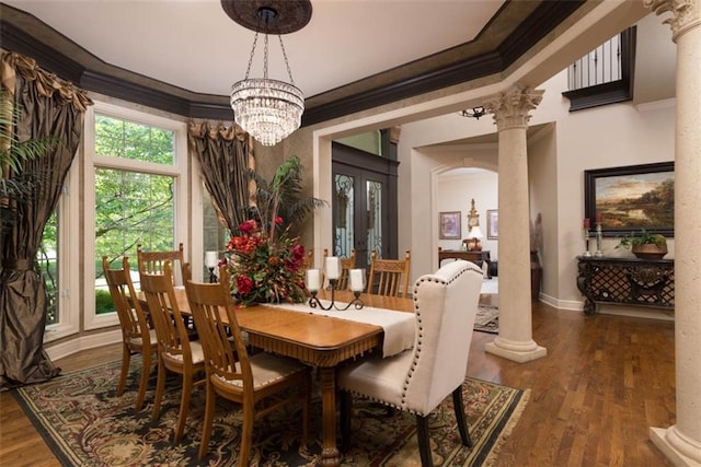 14301 Briar St, Leawood, KS 66224 - dining space featuring ornamental molding, decorative columns, wood finished floors, a chandelier, and arched walkways