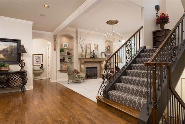 14301 Briar St, Leawood, KS 66224 - entrance foyer with stairway, a fireplace, wood finished floors, arched walkways, and recessed lighting