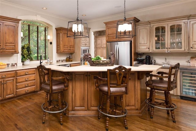 14301 Briar St, Leawood, KS 66224 - kitchen featuring appliances with stainless steel finishes, beverage cooler, a center island, light countertops, and dark wood-type flooring