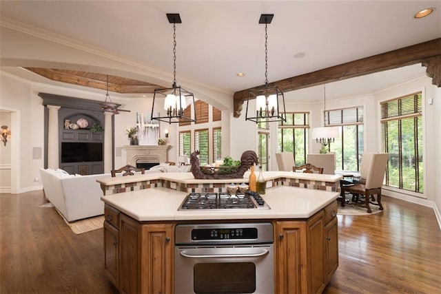 14301 Briar St, Leawood, KS 66224 - kitchen featuring stainless steel appliances, a chandelier, brown cabinetry, open floor plan, and crown molding