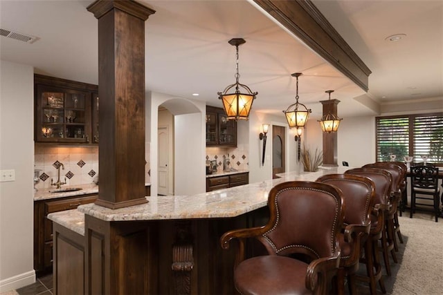14301 Briar St, Leawood, KS 66224 - indoor wet bar with arched walkways, tasteful backsplash, ornate columns, and decorative light fixtures