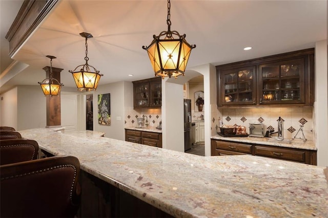 14301 Briar St, Leawood, KS 66224 - bar area with arched walkways, stainless steel refrigerator with ice dispenser, backsplash, recessed lighting, and pendant lighting