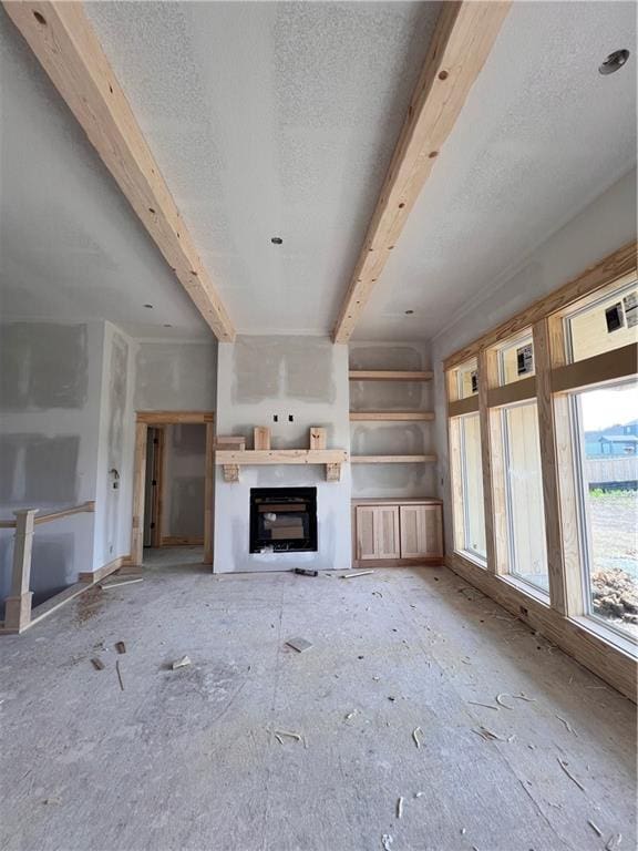 16500 Ingalls St, Gardner, KS 66030 - unfurnished living room featuring a glass covered fireplace, a textured ceiling, and beamed ceiling