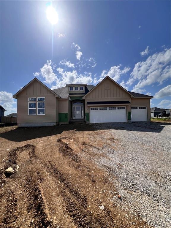 16500 Ingalls St, Gardner, KS 66030 - view of front of property featuring board and batten siding, driveway, a garage, and a shingled roof