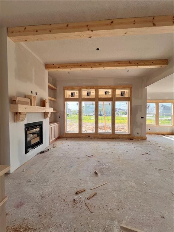 16500 Ingalls St, Gardner, KS 66030 - unfurnished living room with a glass covered fireplace, plenty of natural light, and beamed ceiling