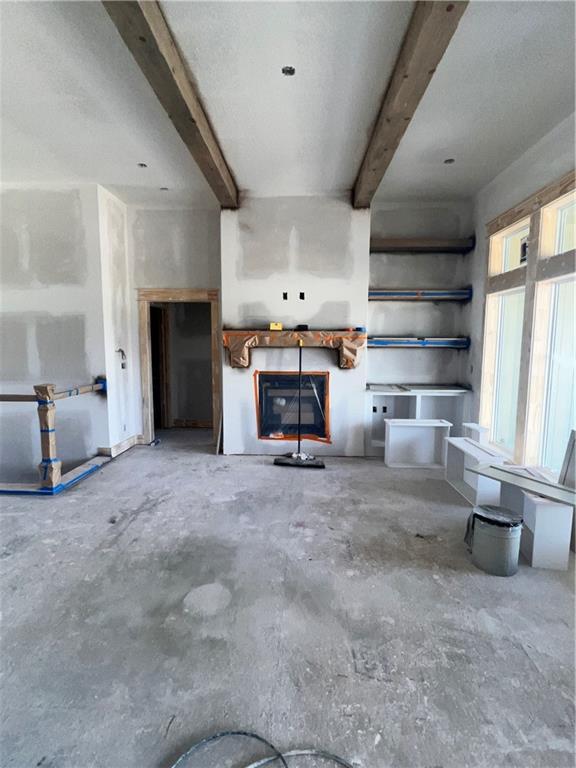16500 Ingalls St, Gardner, KS 66030 - unfurnished living room with beam ceiling and unfinished concrete flooring