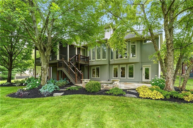 13905 Lucille St, Overland Park, KS 66221 - back of property featuring stairs, a sunroom, and a wooden deck