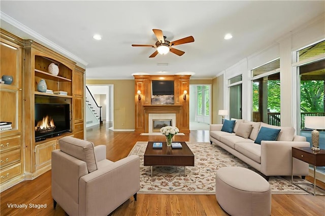 13905 Lucille St, Overland Park, KS 66221 - living area featuring a large fireplace, ornamental molding, ceiling fan, wood finished floors, and stairway