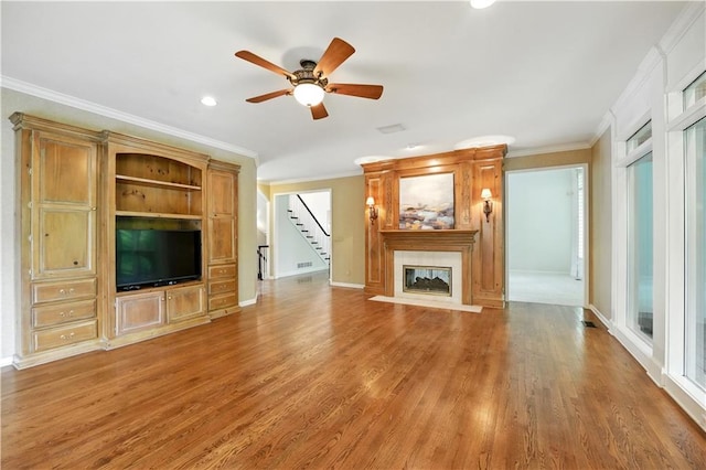 13905 Lucille St, Overland Park, KS 66221 - unfurnished living room featuring crown molding, stairway, wood finished floors, a ceiling fan, and a high end fireplace