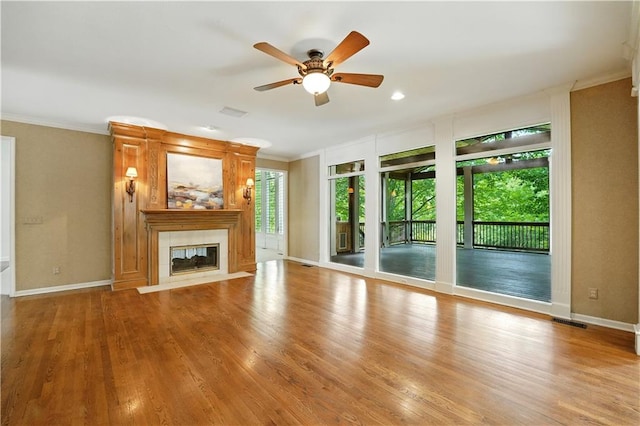 13905 Lucille St, Overland Park, KS 66221 - unfurnished living room featuring ornamental molding, a ceiling fan, a fireplace, and wood finished floors