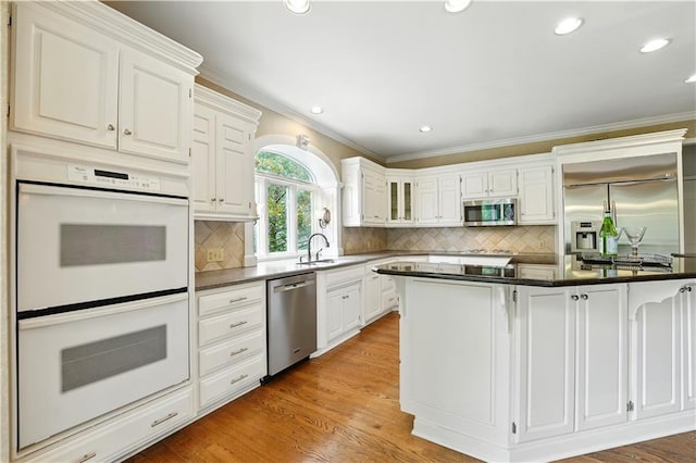 13905 Lucille St, Overland Park, KS 66221 - kitchen featuring stainless steel appliances, crown molding, white cabinetry, dark countertops, and backsplash