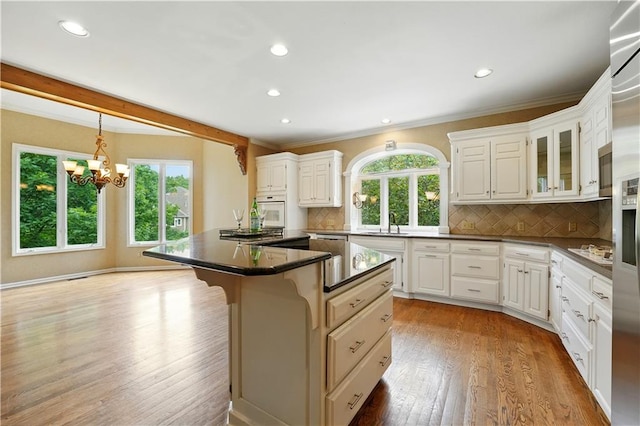 13905 Lucille St, Overland Park, KS 66221 - kitchen with wood finished floors, recessed lighting, a breakfast bar, tasteful backsplash, and a chandelier