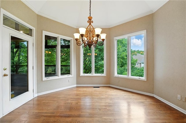 13905 Lucille St, Overland Park, KS 66221 - spare room featuring healthy amount of natural light, wood finished floors, a chandelier, and ornamental molding