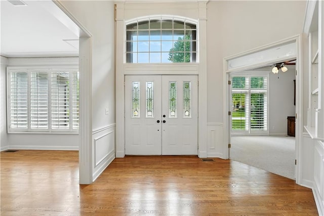 13905 Lucille St, Overland Park, KS 66221 - entrance foyer with wood finished floors, a wainscoted wall, and ceiling fan