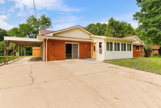 1036 Vilas St, Leavenworth, KS 66048 - single story home featuring an attached carport, concrete driveway, brick siding, and a front lawn