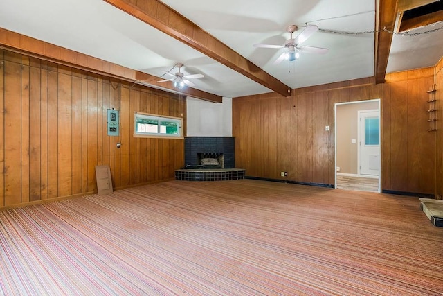 1036 Vilas St, Leavenworth, KS 66048 - unfurnished living room with a ceiling fan, beamed ceiling, wooden walls, and a fireplace with raised hearth