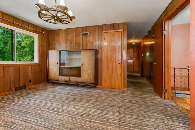 1036 Vilas St, Leavenworth, KS 66048 - carpeted empty room with a chandelier and wooden walls