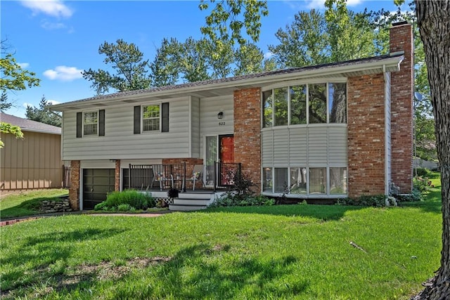522 Kasold Dr, Lawrence, KS 66049 - split foyer home featuring brick siding, a chimney, a front yard, and an attached garage