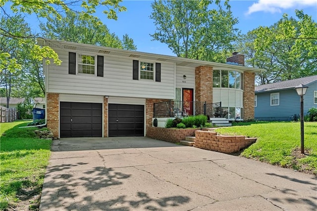 522 Kasold Dr, Lawrence, KS 66049 - raised ranch featuring an attached garage, a front yard, brick siding, concrete driveway, and a chimney