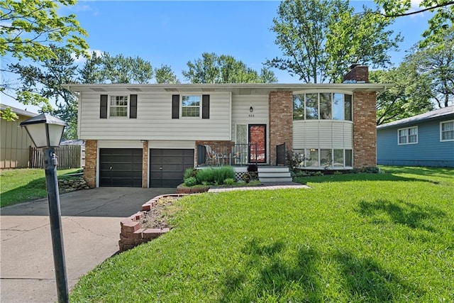 522 Kasold Dr, Lawrence, KS 66049 - bi-level home featuring brick siding, an attached garage, driveway, a front lawn, and a chimney