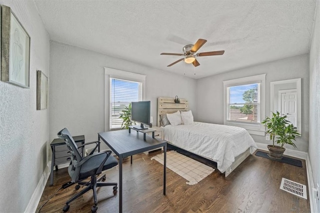 1316 E 42nd St, Kansas City, MO 64110 - bedroom with multiple windows, baseboards, an office area, a textured ceiling, and a textured wall