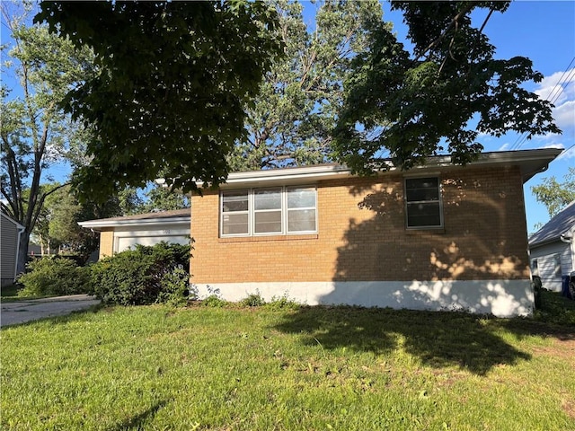 501 Maple Ave, Smithville, MO 64089 - view of home's exterior with brick siding, a lawn, and a garage
