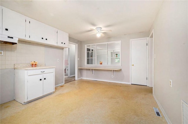 501 Maple Ave, Smithville, MO 64089 - kitchen with ceiling fan, white cabinetry, backsplash, light countertops, and baseboards
