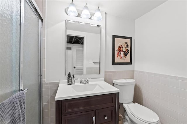 2210 W 69th Ter, Mission Hills, KS 66208 - bathroom featuring tile walls, vanity, toilet, a shower stall, and a wainscoted wall