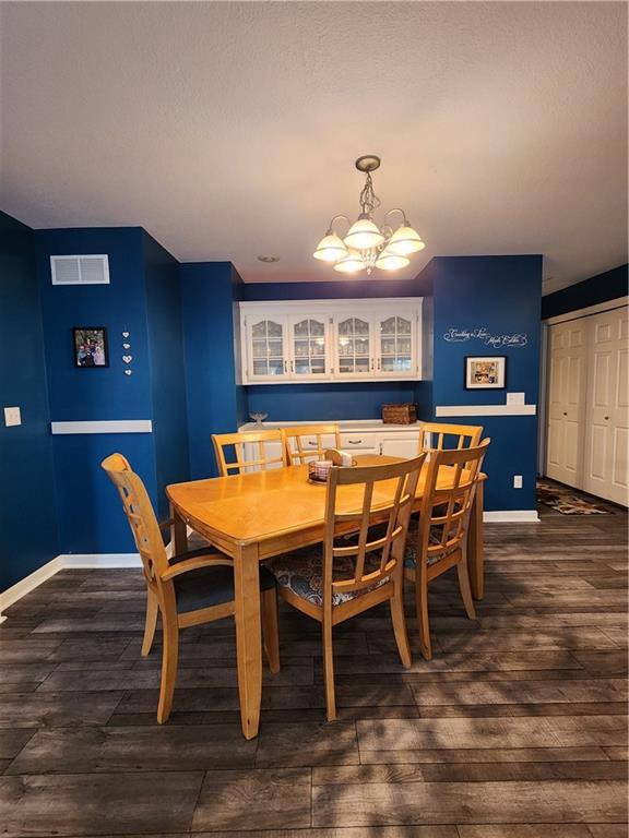 9001 NE 109th Ter, Kansas City, MO 64157 - dining area featuring a chandelier, dark wood finished floors, and baseboards