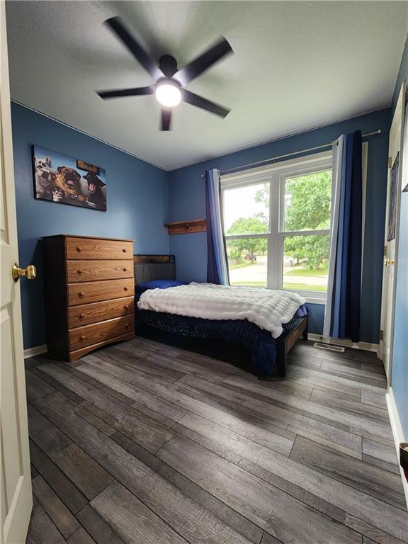 9001 NE 109th Ter, Kansas City, MO 64157 - bedroom featuring dark wood-style flooring, ceiling fan, and baseboards