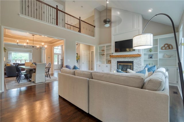13011 Long St, Overland Park, KS 66213 - living area with a chandelier, a fireplace, dark wood-style floors, and high vaulted ceiling