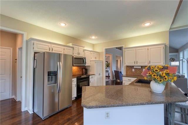 13011 Long St, Overland Park, KS 66213 - kitchen with stainless steel appliances, a peninsula, white cabinetry, dark wood-style flooring, and backsplash