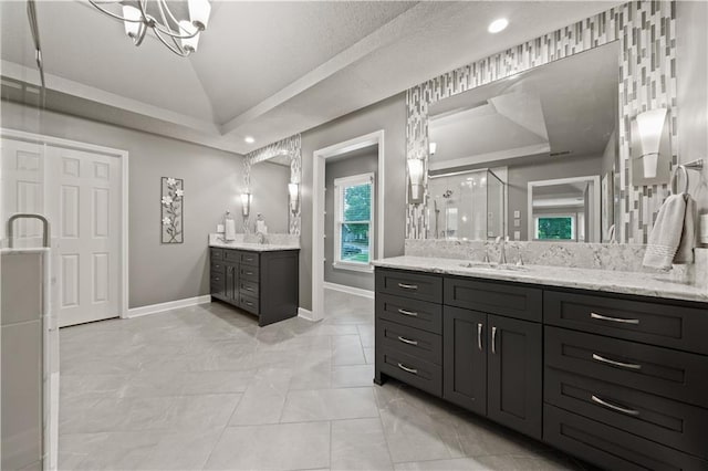 14450 W 146th Ter, Olathe, KS 66062 - full bath featuring two vanities, baseboards, a chandelier, a shower stall, and vaulted ceiling