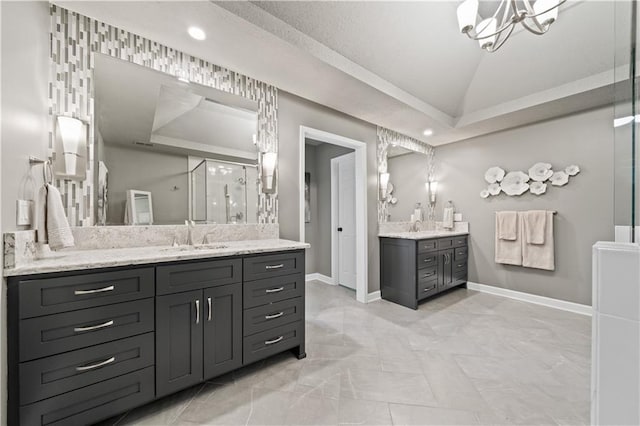 14450 W 146th Ter, Olathe, KS 66062 - bathroom featuring two vanities, a chandelier, a stall shower, baseboards, and lofted ceiling