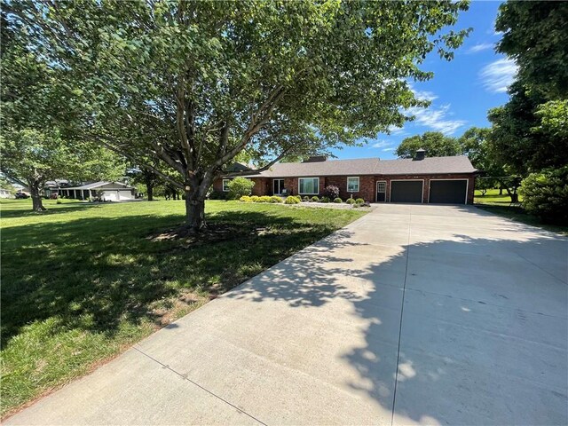 1211 N 6th St, Hiawatha, KS 66434 - ranch-style house featuring a garage, driveway, a front yard, and brick siding