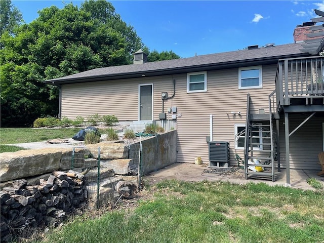 1211 N 6th St, Hiawatha, KS 66434 - rear view of property featuring cooling unit, a chimney, and a patio