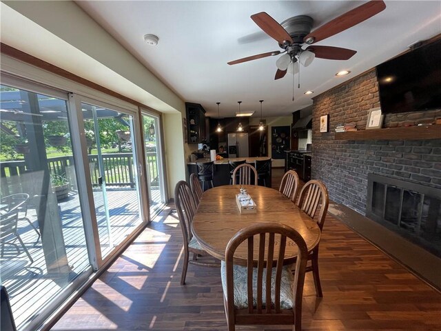 1211 N 6th St, Hiawatha, KS 66434 - dining area featuring wood finished floors, ceiling fan, and a fireplace